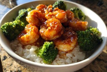Close-up of a Honey Garlic Shrimp Bowl Quick Dinner featuring glazed shrimp, steamed broccoli florets, and white rice in a white bowl.