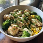 Close-up of a Honey Mustard Chicken Bowl featuring seared chicken pieces, broccoli, corn, and a creamy sauce drizzle.