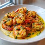 Close-up of plump shrimp coated in a rich, yellow lemon butter sauce with garlic and fresh parsley, showcasing the Lemon Butter Shrimp with Garlic Flavor.