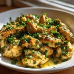 Close-up of golden Lemon Garlic Butter Chicken Easy Skillet pieces smothered in sauce and fresh parsley.