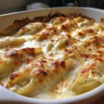 Close-up of baked Cheesy Chicken Stuffed Pasta with Cream Sauce, featuring golden-brown melted cheese.