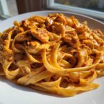 Close-up of rich, creamy Cajun chicken pasta with fettuccine noodles and seasoned chicken pieces.