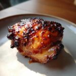Close-up of a perfectly cooked Honey Garlic Chicken Thighs with very crispy, glazed skin.