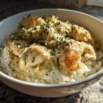 Close-up of Garlic Butter Chicken and Rice One Pot Dinner topped with grated cheese and parsley.