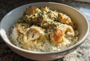 Close-up of Garlic Butter Chicken and Rice One Pot Dinner topped with grated cheese and parsley.